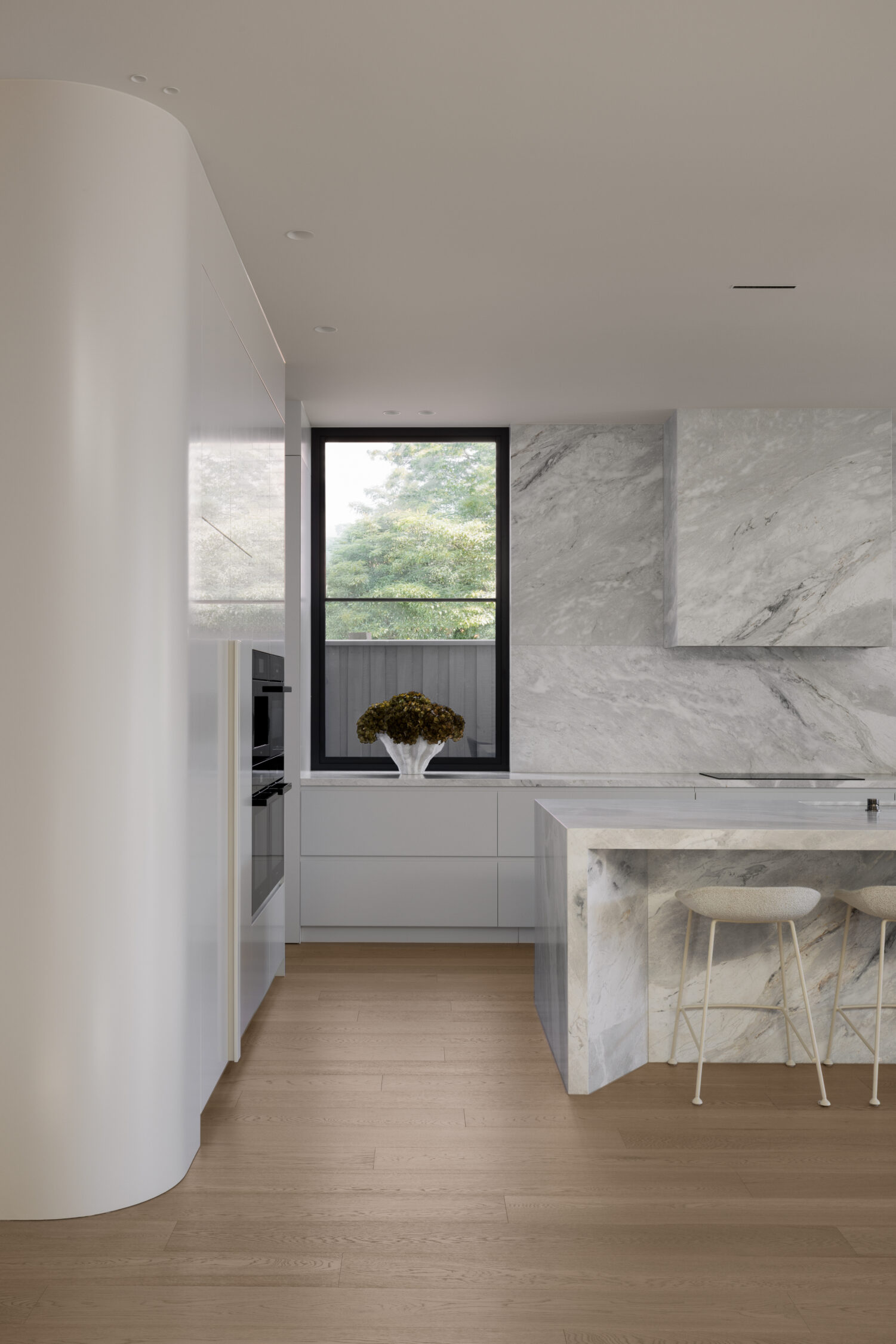 Kitchen with curved floor to ceiling joinery and Italian Marble