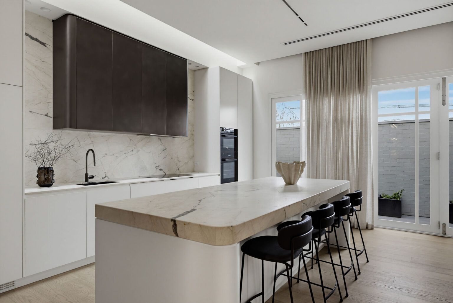 Kitchen featuring leathered marble and metalcote rangehood